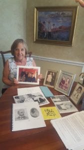 Nancy McCrory holds a family photo surrounded by other archives from her family’s history