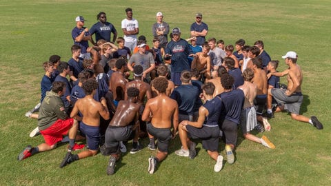estero football team huddle