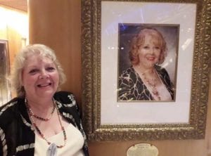 10 years after she was crowned Godmother of Royal Caribbean Independence of the Seas, Elizabeth Hill stands next to her portrait