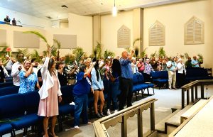 The congregation at Estero Church waves their palms