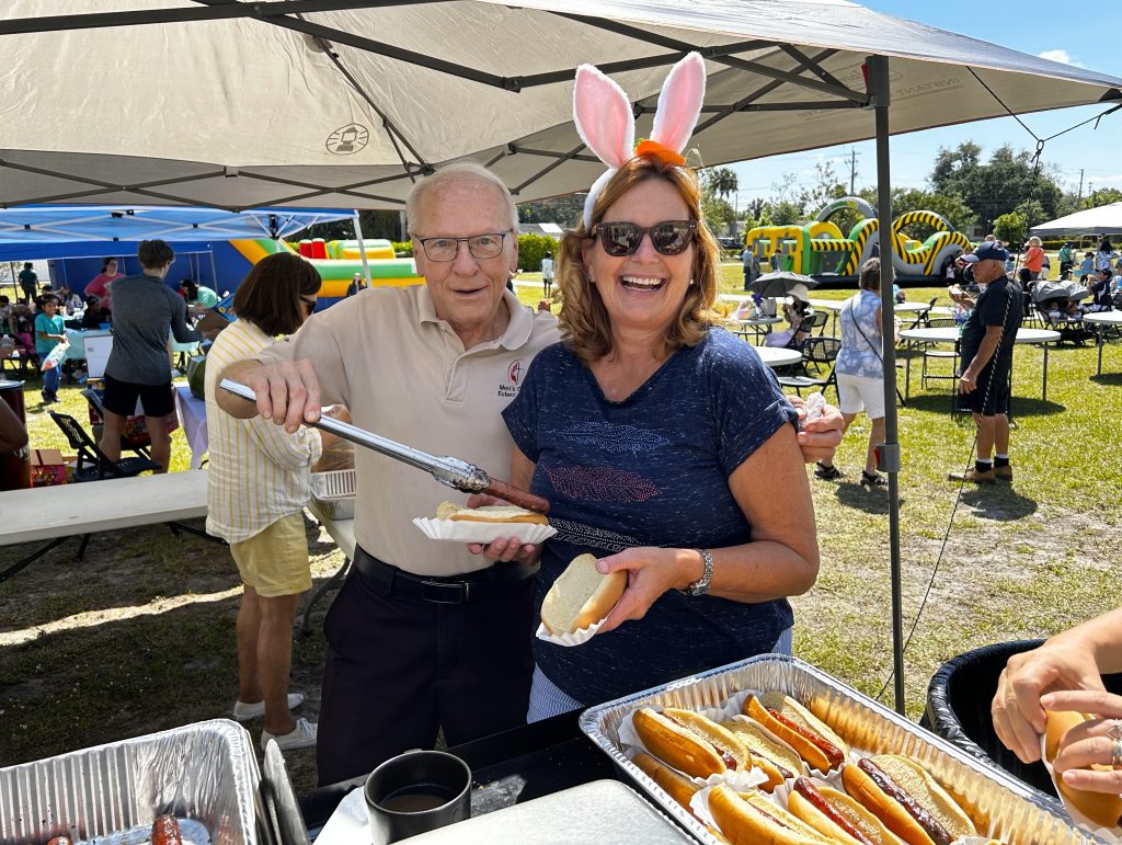 William Smith and Amy Pitzer serve hot dogs at Estero Church's Easter egg hunt